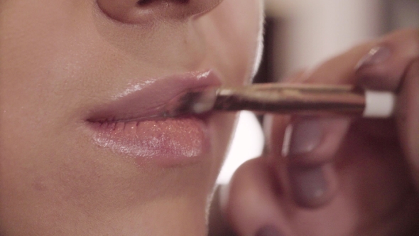 The Makeup Artist Applying Lip Gloss