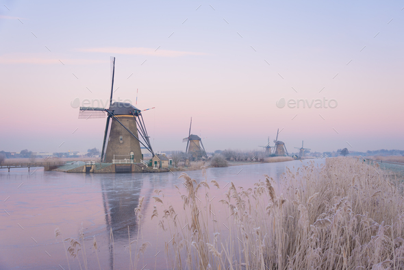 Pastel sunrise over windmills in winter - Stock Photo - Images