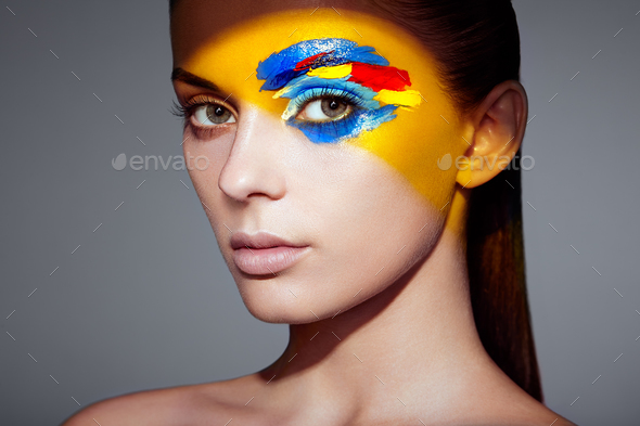 Fashion model woman with colored face painted - Stock Photo - Images