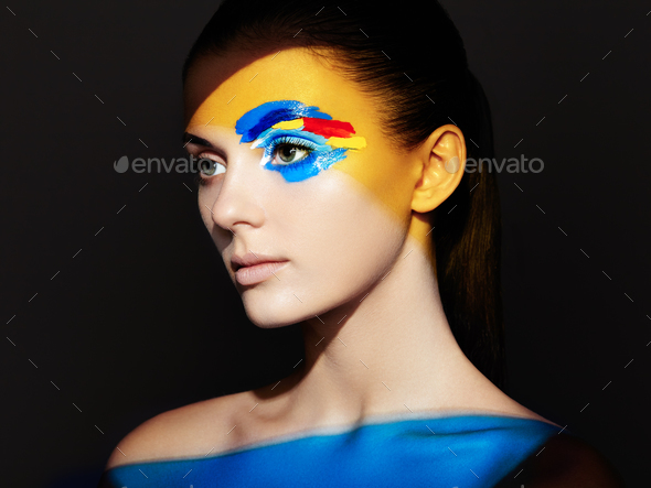 Fashion model woman with colored face painted - Stock Photo - Images