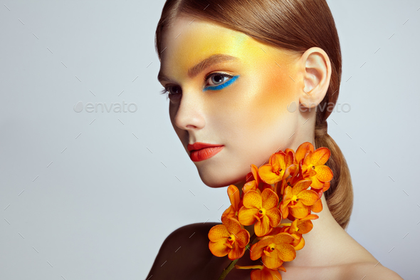 Portrait of beautiful young woman with orchid - Stock Photo - Images