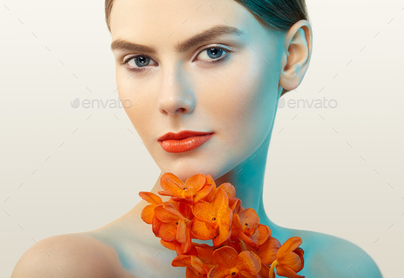 Portrait of beautiful young woman with orchid - Stock Photo - Images