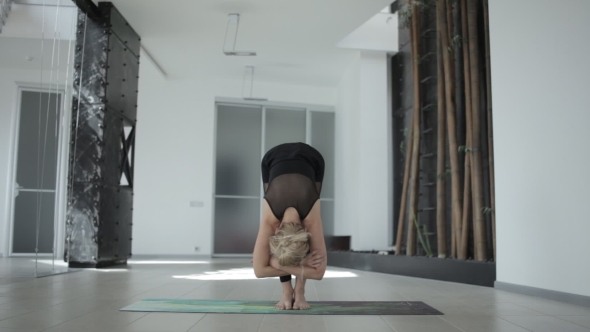 Young Cute Girl Engaged in Yoga in a Spacious White Studio