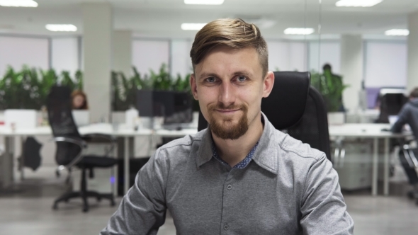 Young Business Man with a Beard Smiling at the Workplace in Office