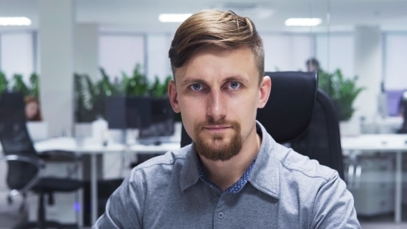 Business Man with a Beard Turns His Head To the Camera and Smiling