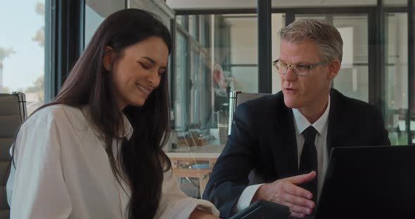 Close up of two business partners having a meeting in an office to discuss a new project.Slow motion alt