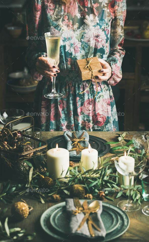 Woman holding glass of champaigne and gift box, Christmas eve - Stock Photo - Images