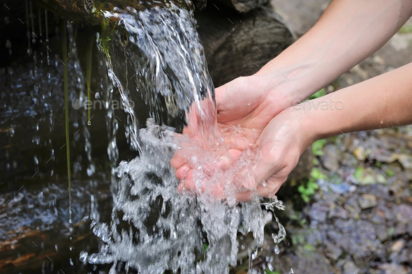Drinking water and natural water in the hands. - Stock Photo - Images