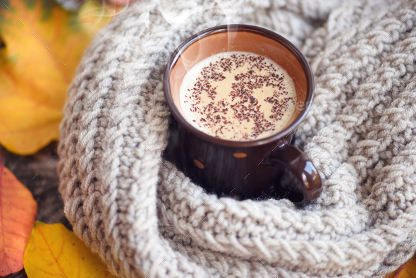 Autumn leaves, hot cup of coffee and a warm scarf on wooden tabl - Stock Photo - Images