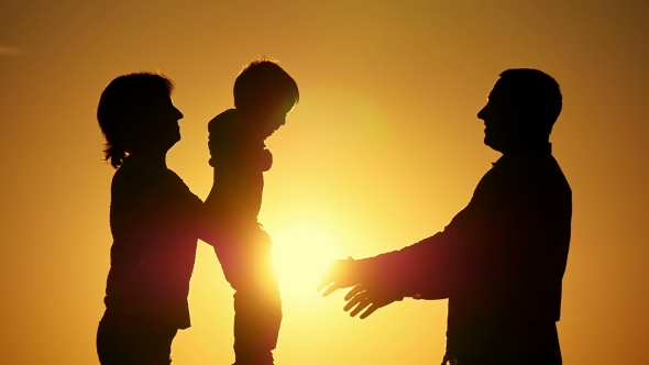 Silhouette of Father of Mother and Child. The Mother Passes the Father of the Child To the Sunset in alt