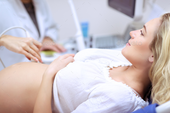Pregnant woman doing ultrasound scan - Stock Photo - Images