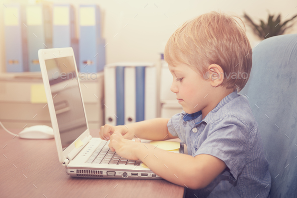 Little boy working on the laptop - Stock Photo - Images