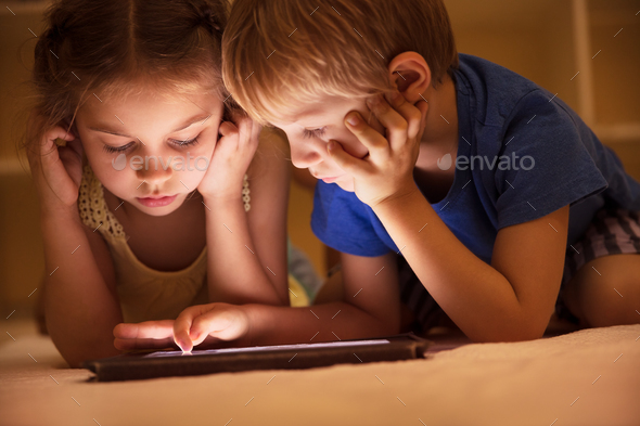 Two little kids watching cartoons - Stock Photo - Images