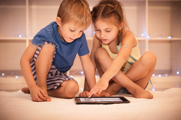 Two happy children playing on the tablet - Stock Photo - Images