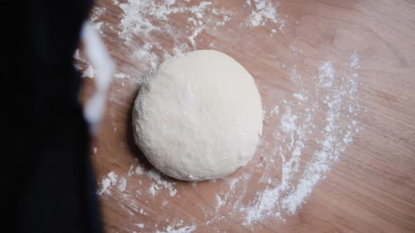 White flour dough is covered by a black cloth to be left to prove. alt