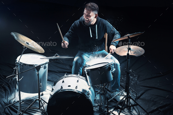 Drummer rehearsing on drums before rock concert. Man recording music on drum set in studio Stock Photo by master1305