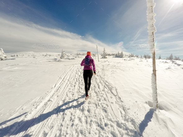 Running woman on winter trail, snow and white mountains - Stock Photo - Images