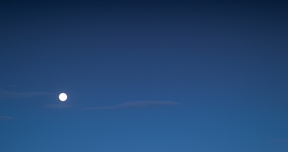 The Moon Rises in the Blue Sky