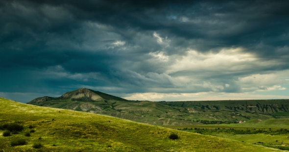 A Whirlwind of Dark Clouds Over Green Hills