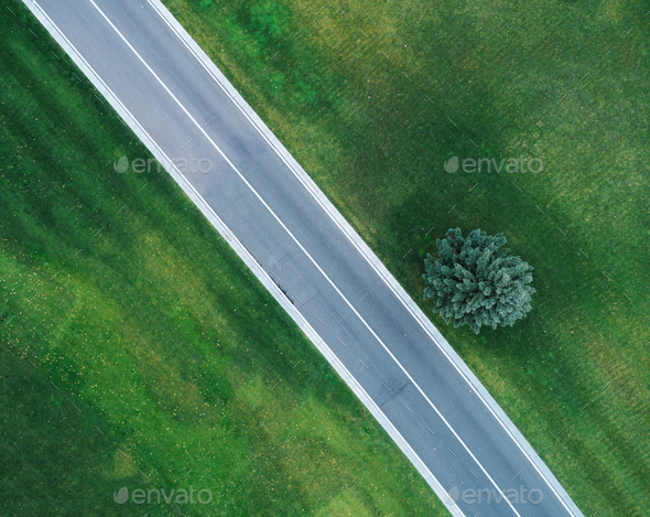 Aerial view of road through beautiful green field - Stock Photo - Images