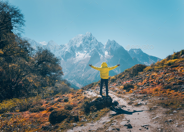 Standing man on the stone against snowy mountains - Stock Photo - Images