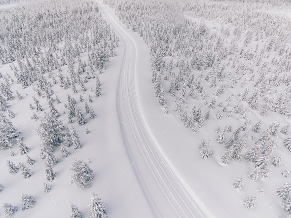 Aerial view of the road in the winter snow forest in Finland Stock Photo by nblxer