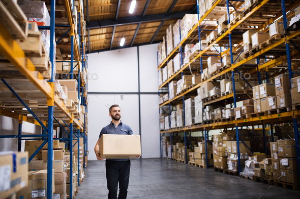 Male warehouse worker with a large box. Stock Photo by halfpoint | PhotoDune