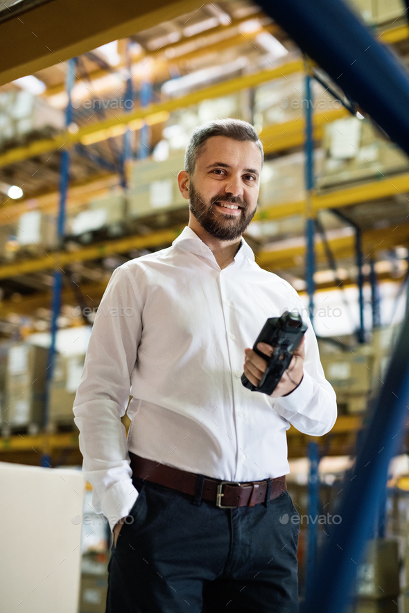 Warehouse worker or supervisor with barcode scanner. Stock Photo by halfpoint
