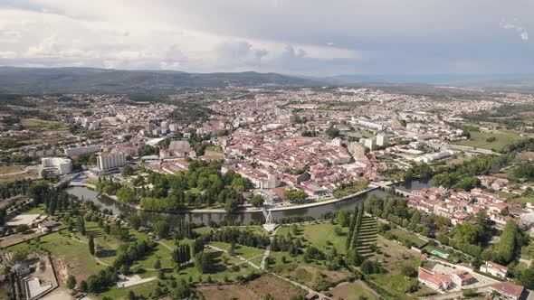 Aerial wide orbiting shot over Chaves Cityscape surrounded by Nature, Cloudy day alt
