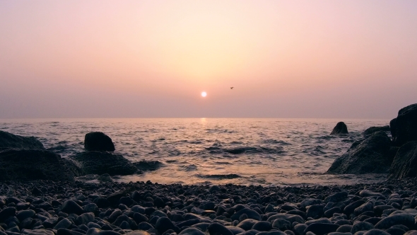 of Sunrise Above the Sea with Rocks in Water