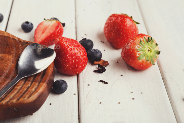 Fresh strawberries, heartshaped dessert spoon on white rustic planks with copy space - Stock Photo - Images