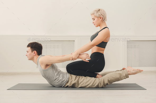 Young man with yoga instructor in fitness club - Stock Photo - Images