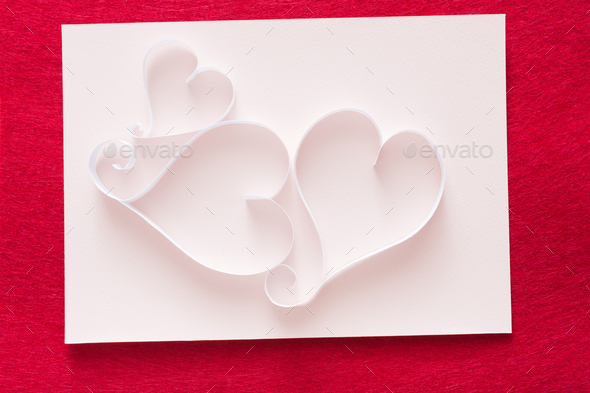 Valentine background with handmade paper heart shapes decoration on white shit of paper on red felt - Stock Photo - Images