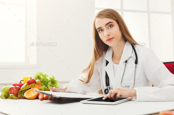 Female nutritionist working on digital tablet - Stock Photo - Images