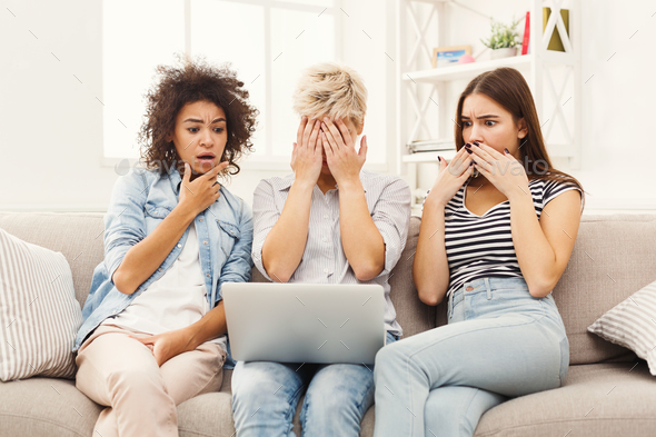 Three beautiful frightened women using laptop at home Stock Photo by Milkosx