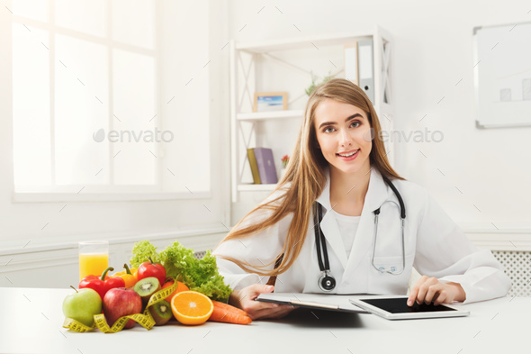 Female nutritionist working on digital tablet - Stock Photo - Images