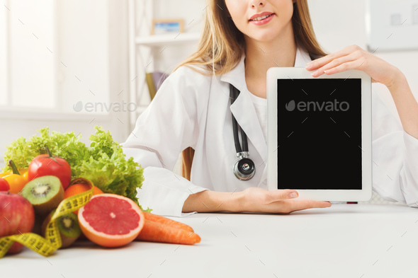 Doctor nutritionist and holding digital tablet - Stock Photo - Images