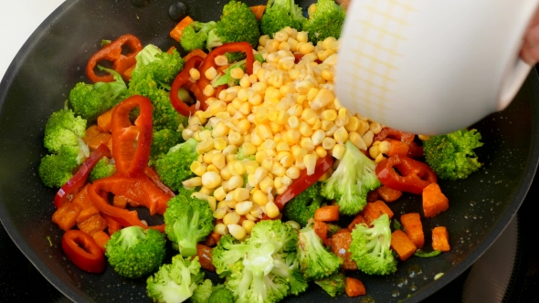 Pour Corn Kernels Into a Frying Pan with Fried Vegetables