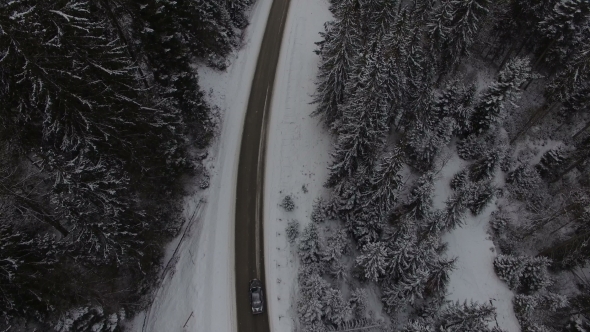 Car Driving on Winter Country Road in Snowy Forest, Aerial View From Drone alt