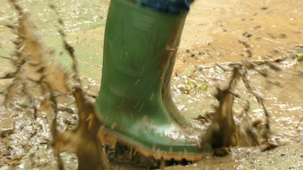 Rubber Boots Jumping Over Dirty Puddles