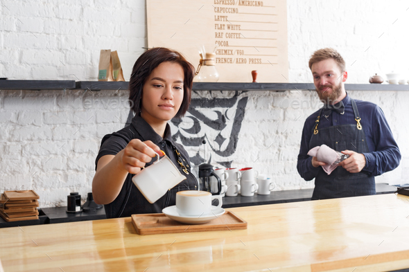 Male and female bartenders brewing fresh coffee at cafe interior - Stock Photo - Images