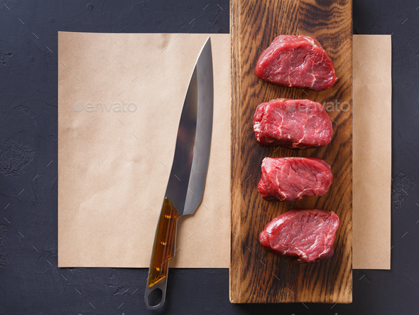 Raw beef filet mignon steaks on wooden board and craft papper - Stock Photo - Images
