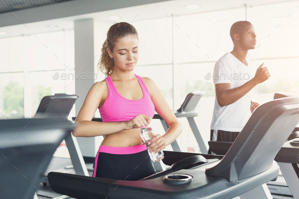 Man and woman, couple in gym on treadmills - Stock Photo - Images