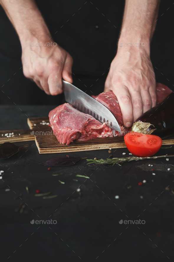 Chef cutting filet mignon on wooden board at restaurant kitchen - Stock Photo - Images