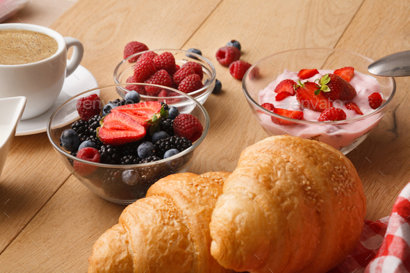 Continental breakfast with croissants and berries on natural wood - Stock Photo - Images
