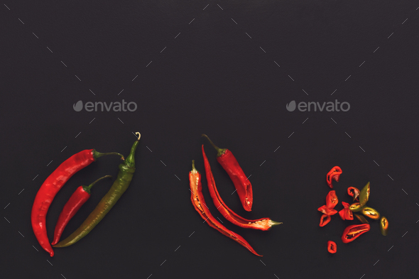 Whole and cut chili pepper on black isolated background - Stock Photo - Images