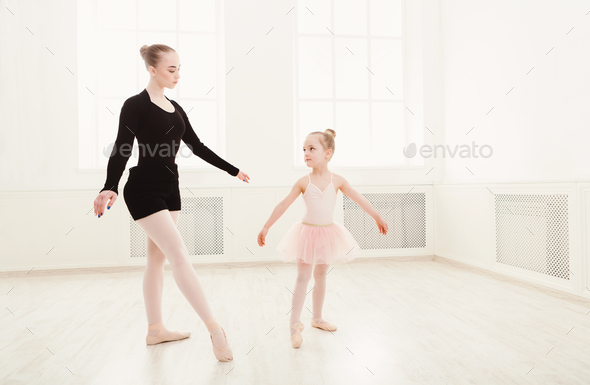 Little girl looking at professional ballet dancer Stock Photo by Milkosx