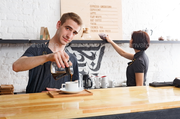 Male and female bartenders brewing fresh coffee at cafe interior - Stock Photo - Images