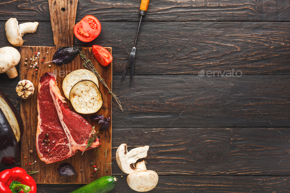 Raw t-bone steak on wooden board - Stock Photo - Images