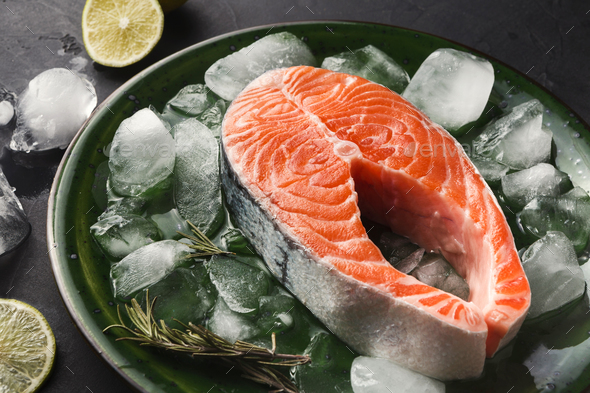 Fresh salmon with ice at dark background - Stock Photo - Images